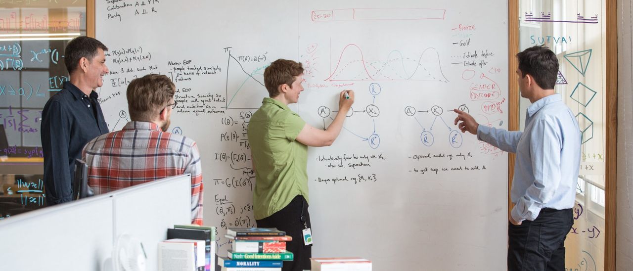A group of researchers working at a whiteboard